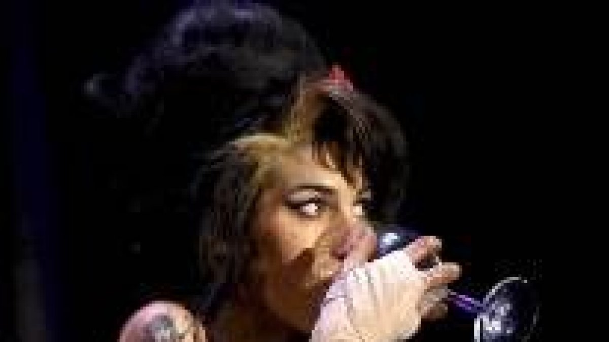 La cantante británica Amy Winehouse bebiendo sobre el escenario