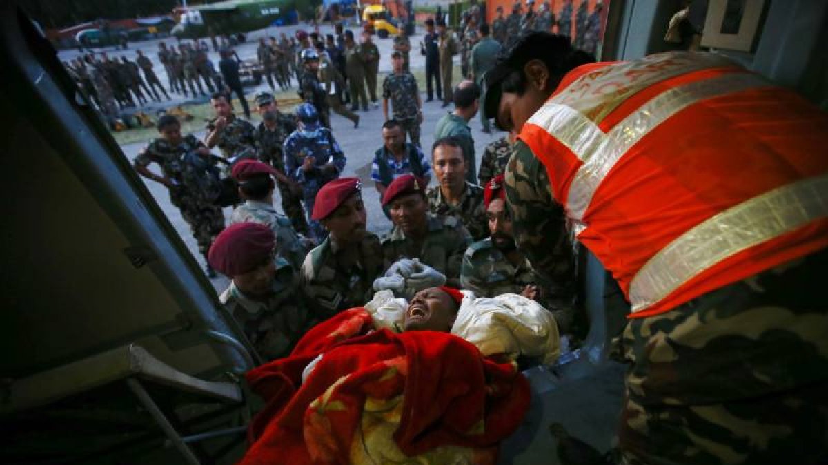 Soldados nepalíes fueron registrados este martes al trasladar a un herido, tras un terremoto de 7,3 grados en la escala Richter, en el aeropuerto de Katmandú (Nepal).