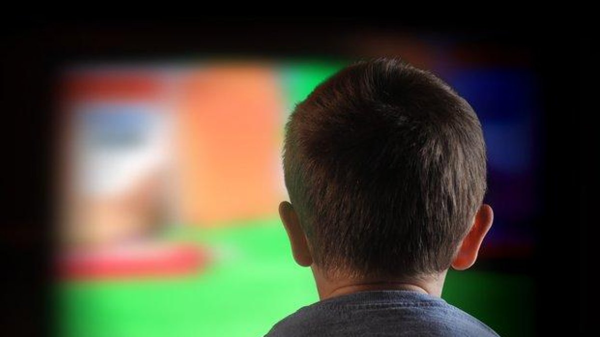 Un niño mira la televisión.