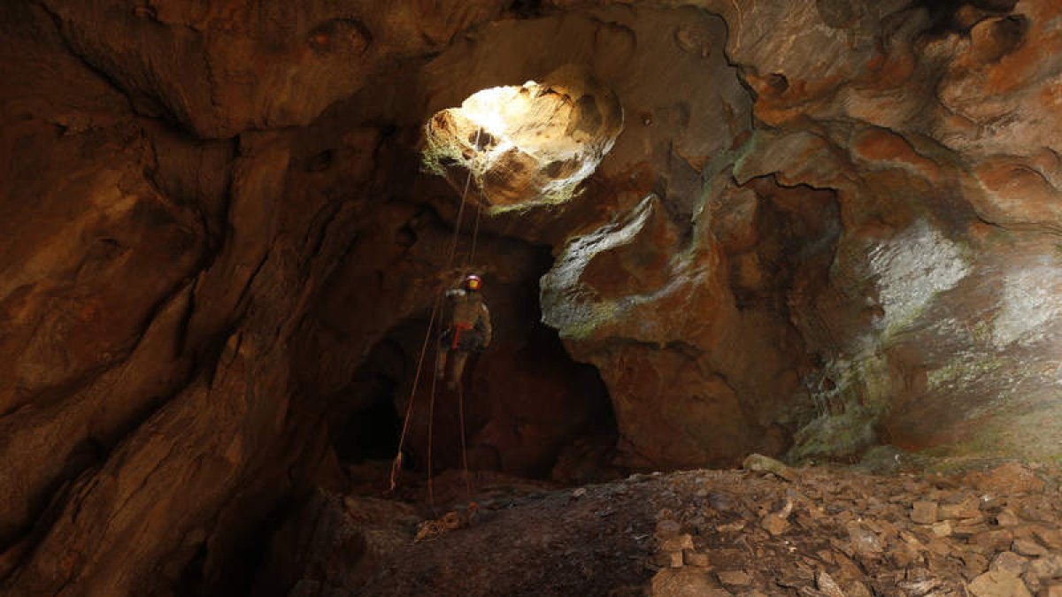 Un especialista del Greim desciende desde la entrada a la cueva de Viñayo