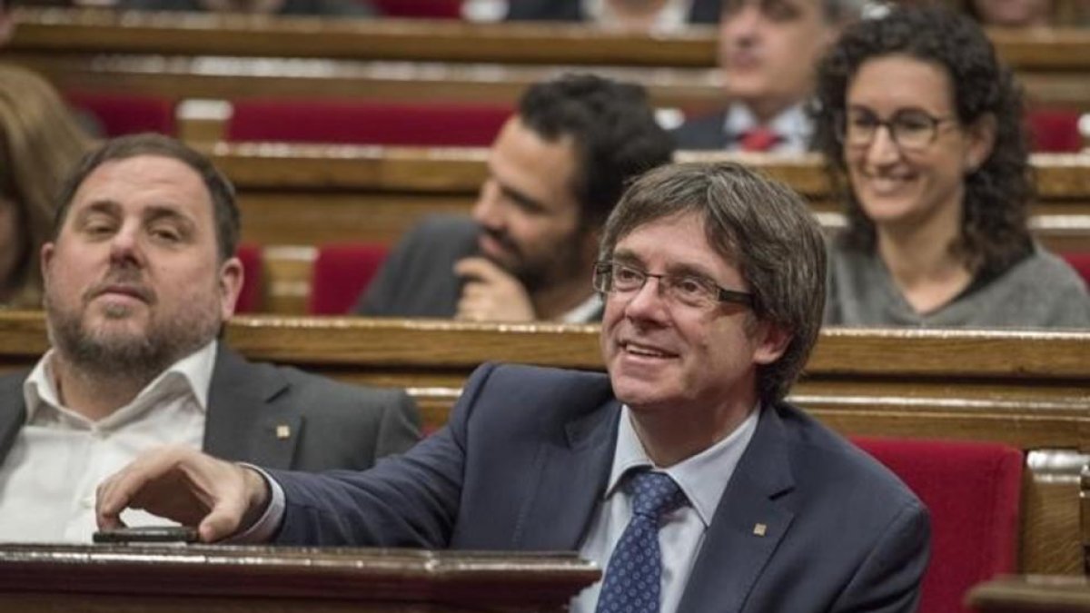 Carles Puigdemont, junto a Oriol Junqueras, en el Parlament.