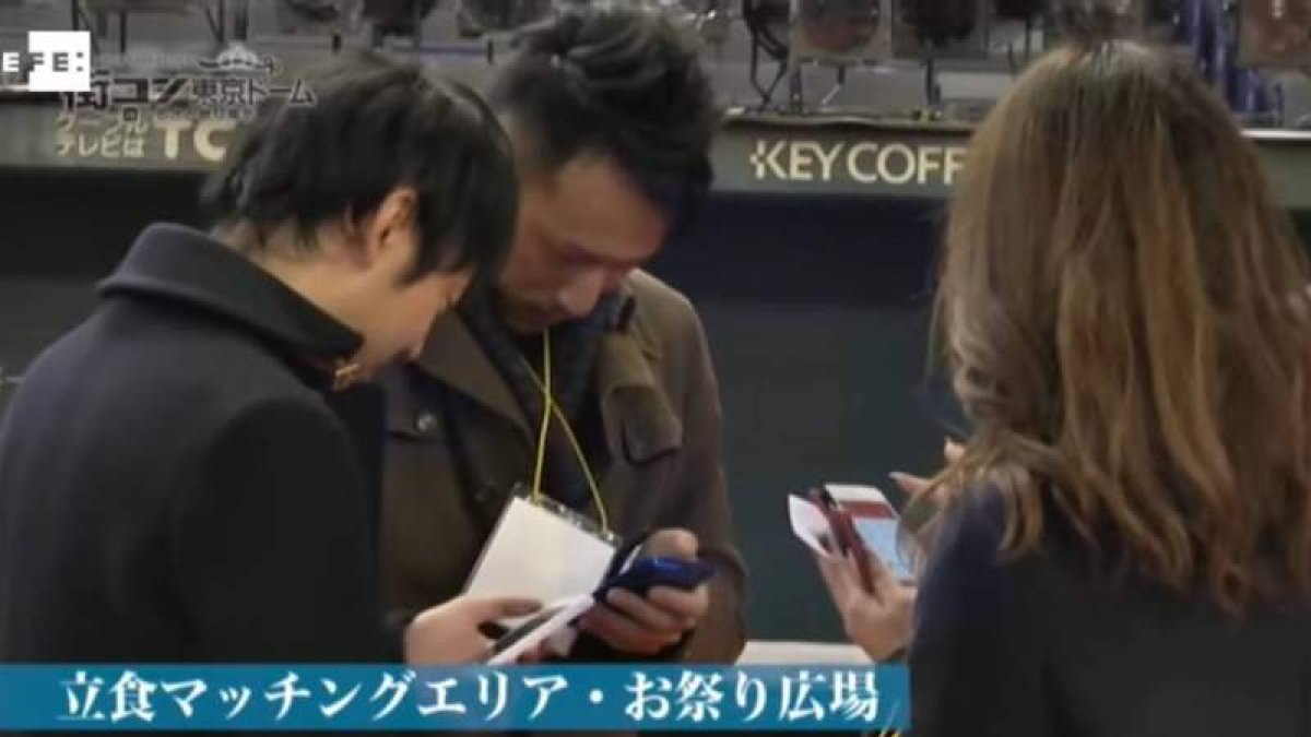 Imagen de un video en el que aparecen jóvenes revisando en sus móviles algunas de las citas de solteros en Japón. EFE