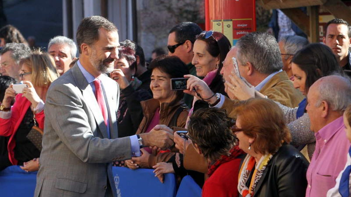 El Príncipe de Asturias saluda a un grupo de vecinos.