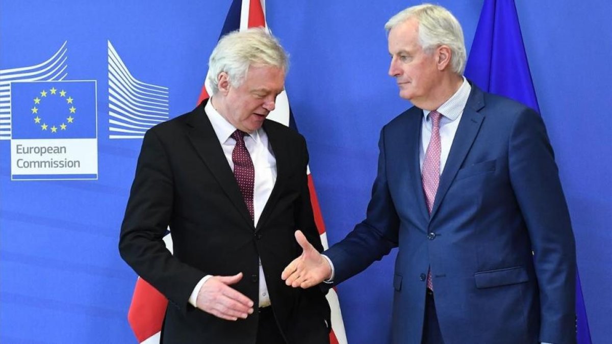Michel Barnier tiende la mano a David Davis en la sede de la Comisión Europea, en Bruselas.