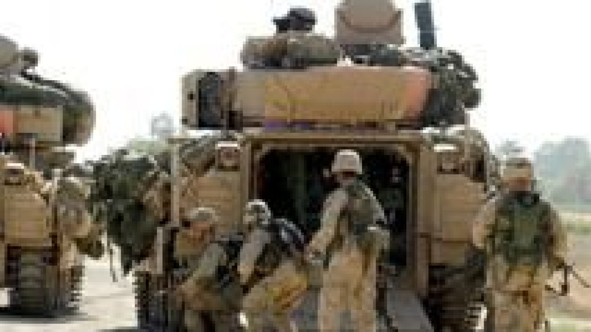 Soldados norteamericanos se protegen tras su vehículo en Balad, a 60 kilómetros al norte de Bagdad