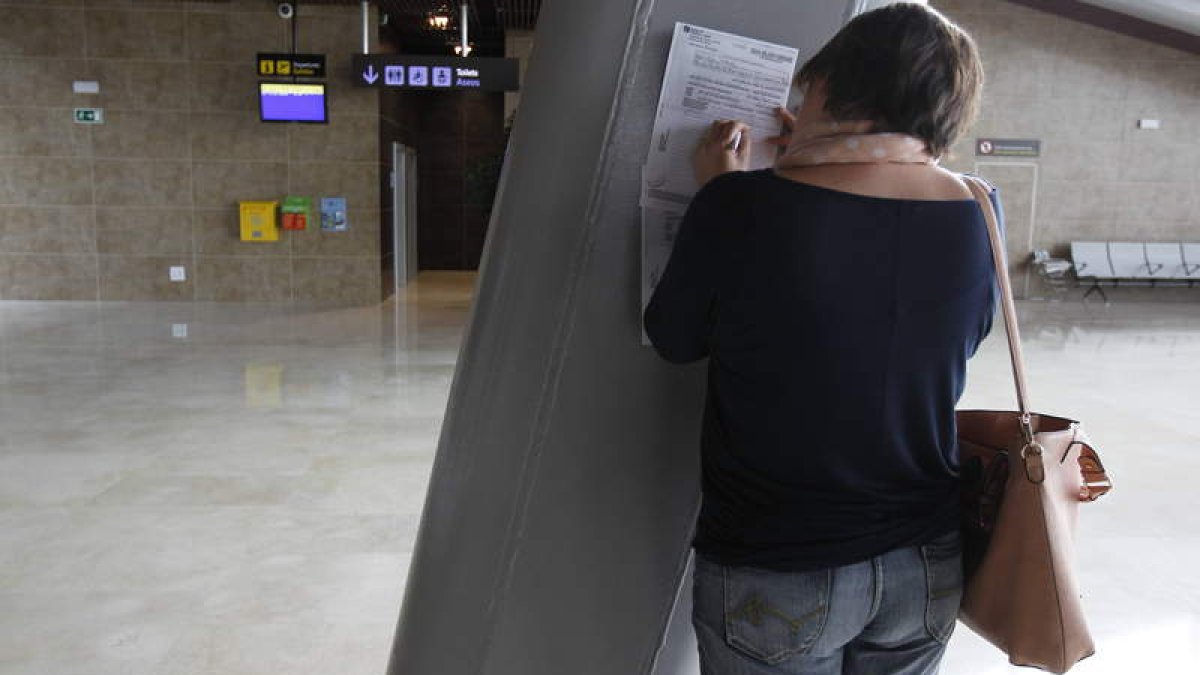 Una pasajera rellena una hoja de reclamaciones en el aeropuerto de León ante una cancelación de vuelos, hace 11 meses