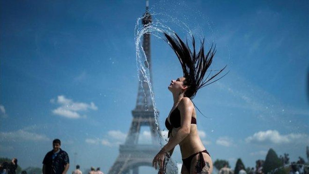 Una mujer se refresca en las fuentes de la explanada de Trocadero, en París.