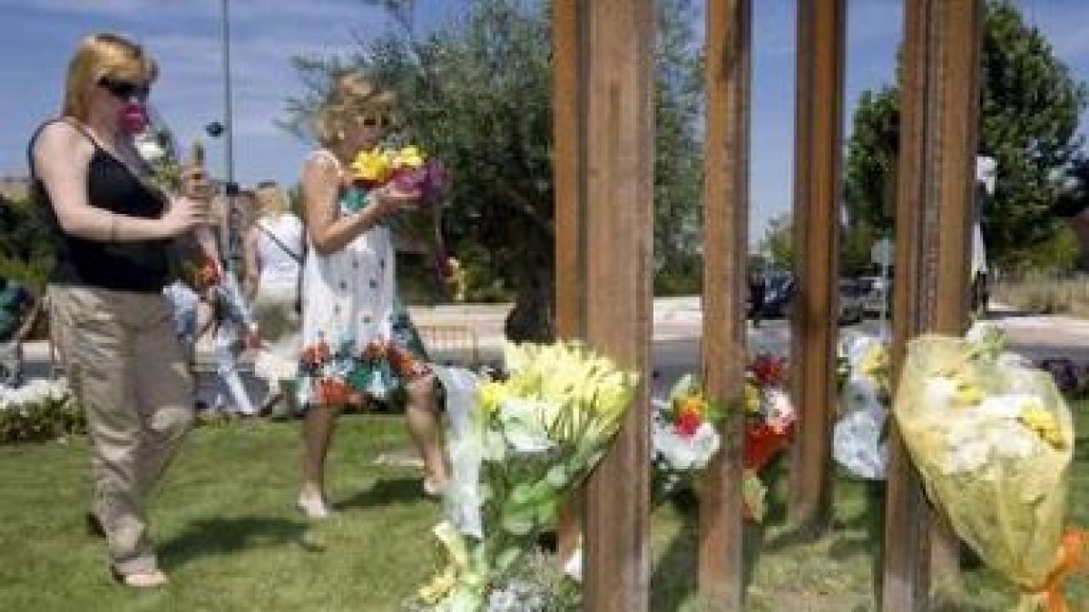 Familiares de las víctimas del incendio depositan flores en el monumento.