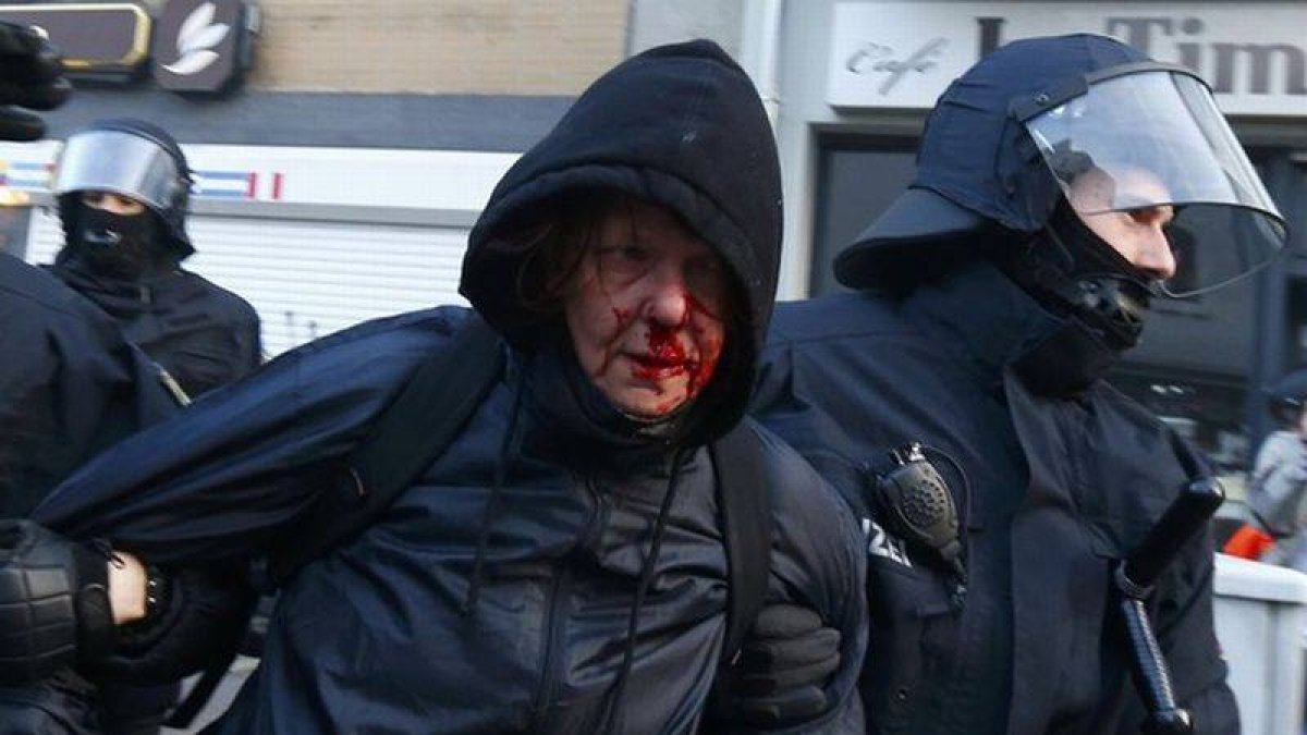 La policía detiene a un manifestante 'Blockupy' herido en la cara.