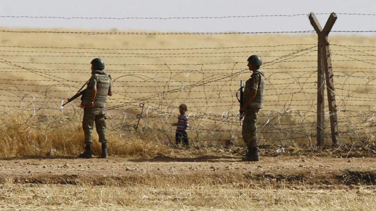 Un niño sirio espera tras las vallas de la frontera para cruzar hacia Turquía cerca de Akcacale (sureste), en el 2015.
