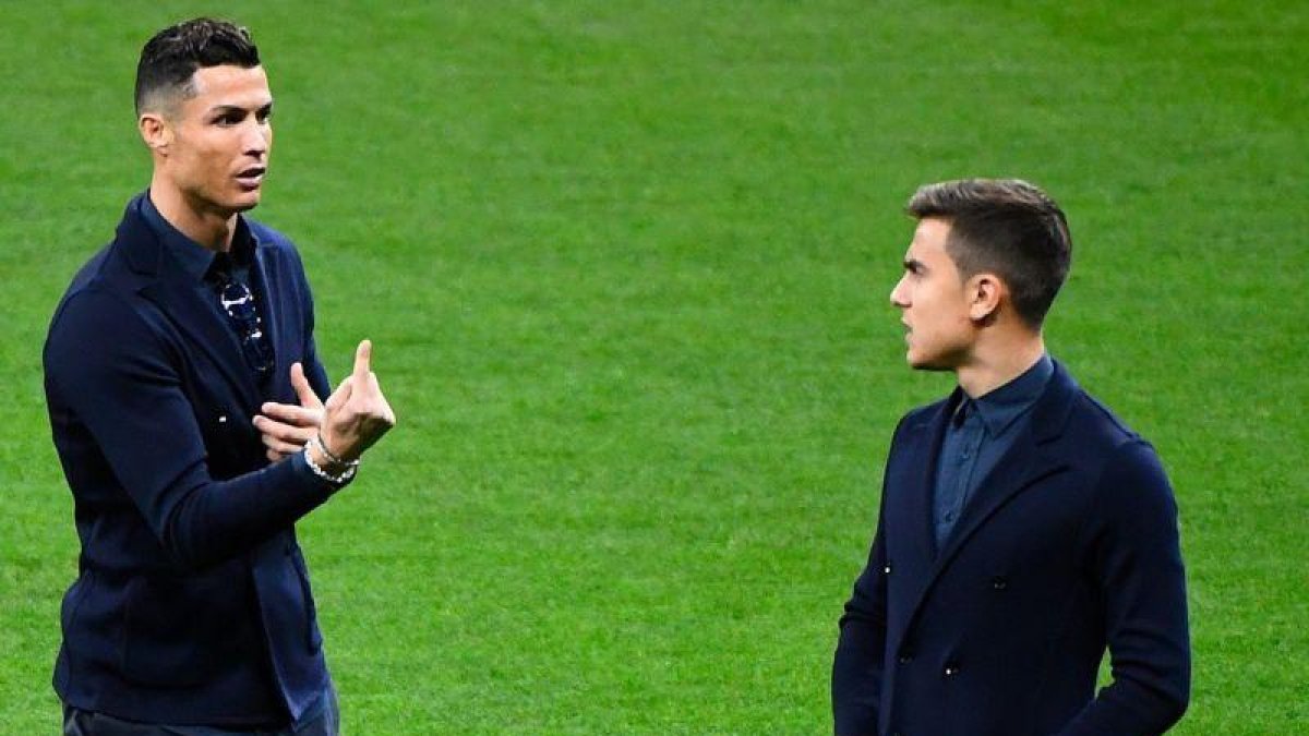 Cristiano Ronaldo (i) charla con Paulo Dybala en sobre el césped del Metropolitano.