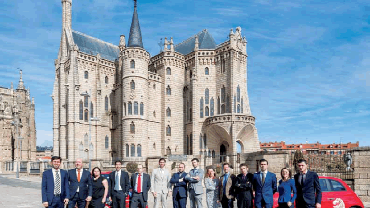 El equipo de Red Lion, junto a los tres socios y gerentes de la empresa, posan delante del Palacio de Gaudí, en Astorga.