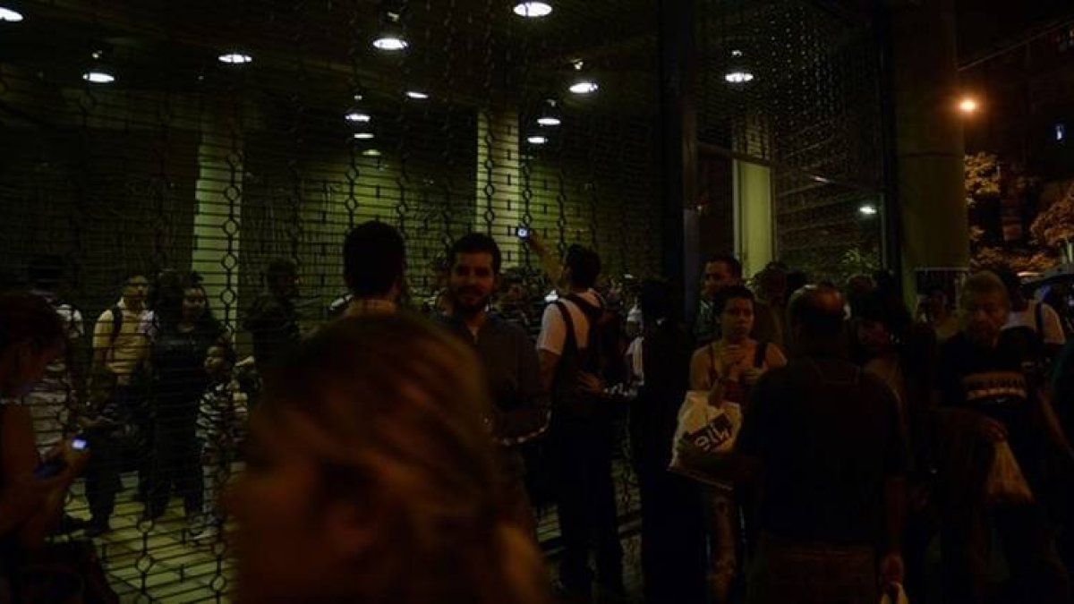 Ciudadanos venezolanos a la puerta de una estación de metro, durante el apagón, este lunes en Caracas.