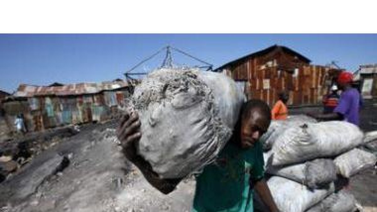 Un hombre traslada un saco de carbón del Puerto de La Saline para su venta en los mercados de Puerto