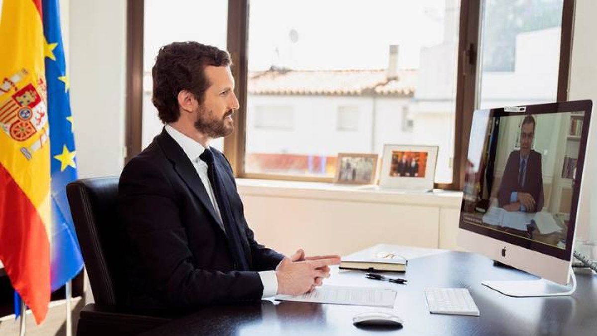 El líder del Partido Popular, Pablo Casado (izq), mantiene una videoconferencia con el presidente del Gobierno español, Pedro Sánchez. DAVID MUDARRA