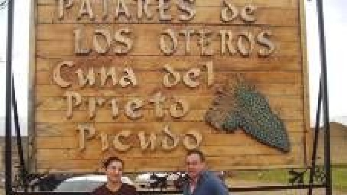 Alcalde y mesonera ante el cartel que da entrada al pueblo de Pajares de los Oteros