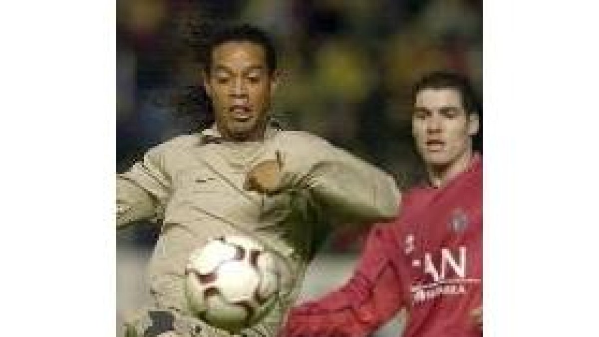 El jugador del Osasuna, Antonio López, a la derecha, trata de controlar el balón frente a Ronaldinho