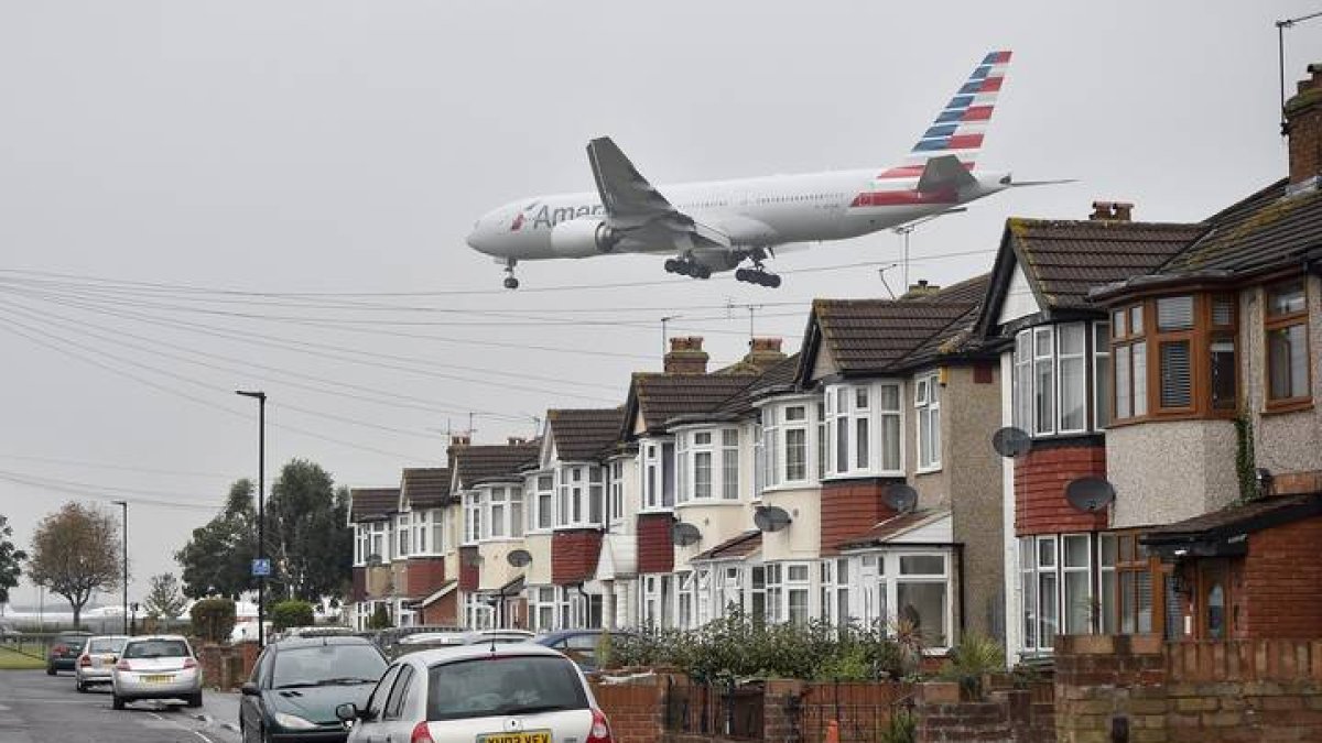 Un avión de British Airways sobrevuela unas casas cercanas al aeropuerto de Heathrow en Londres. HANNA MCKAY