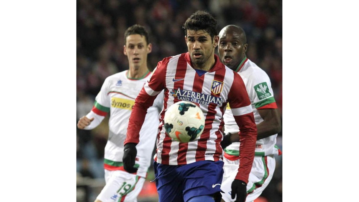 Diego Costa se escapa de dos defensores del Granada.