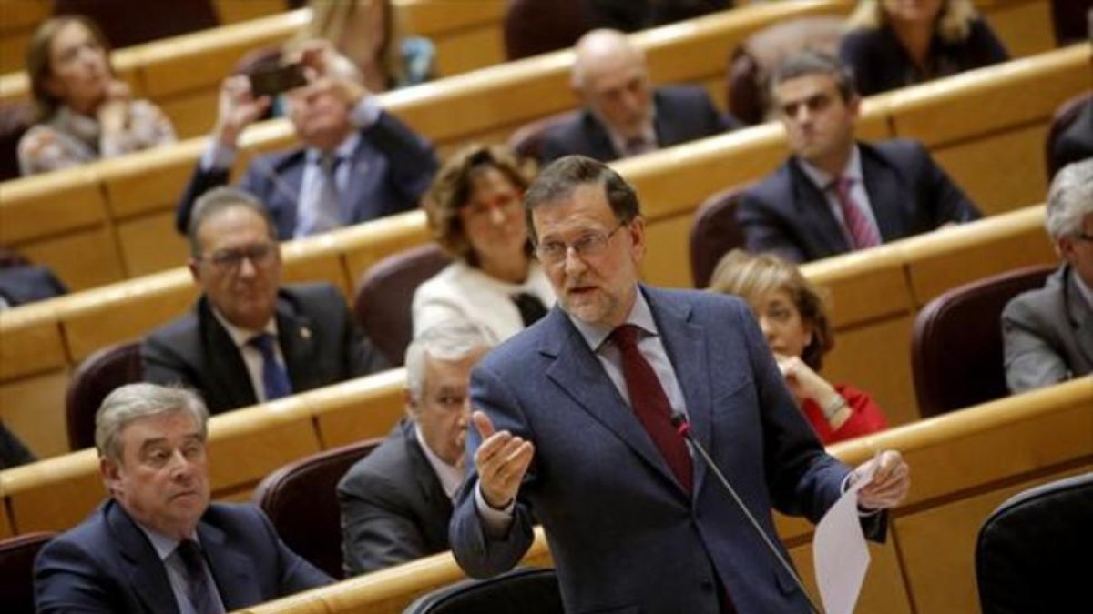 El presidente del Gobierno, Mariano Rajoy, habla desde su escaño en el pleno del Senado.