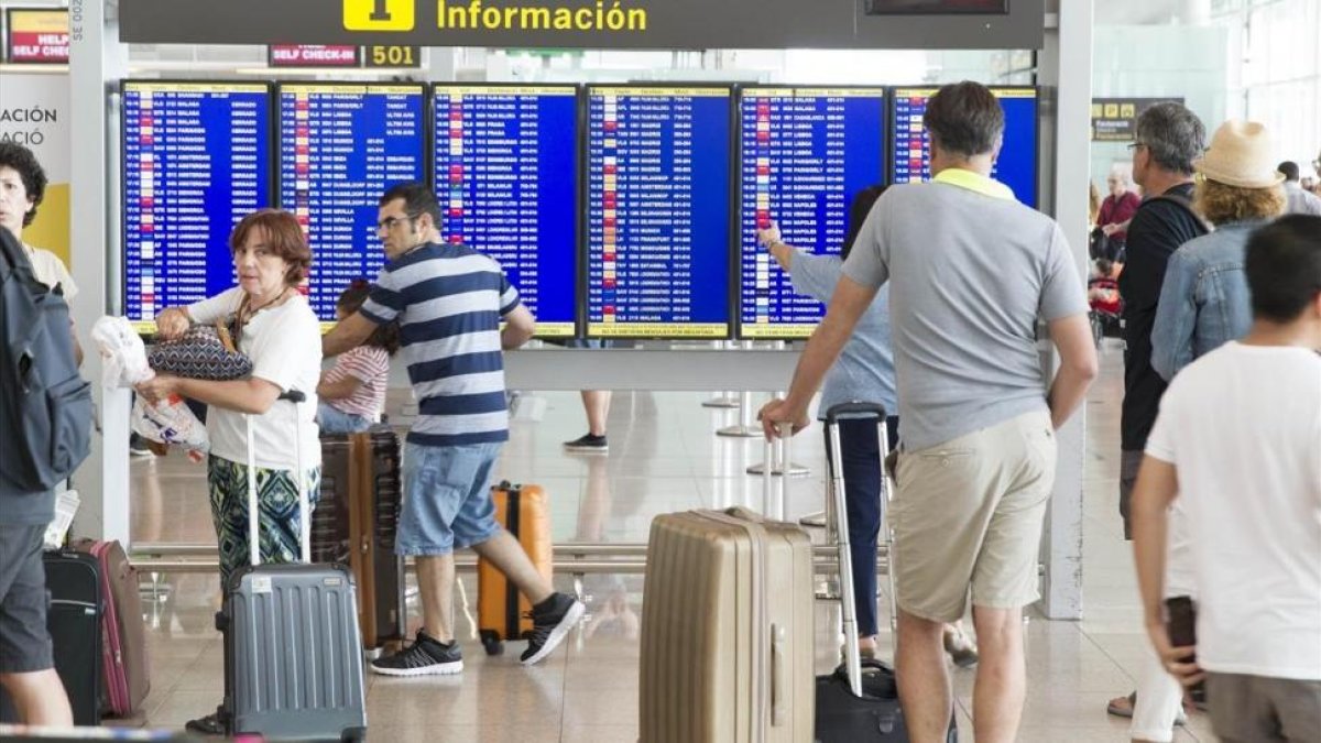 Pasajeros esperando en el aeropuerto de El Prat.