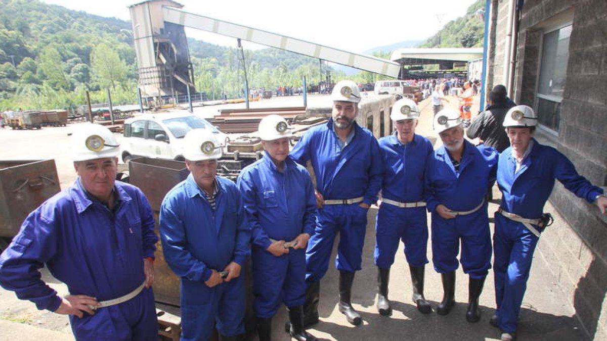 Siete de los ocho mineros que permanecieron 52 días encerrados en el pozo Calderón de Laciana, con el pozo Santa Cruz al fondo.