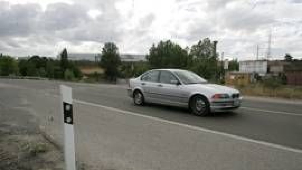 Un vehículo circula por la carretera de acceso al polígono de La Llanada, en la zona del Montearenas