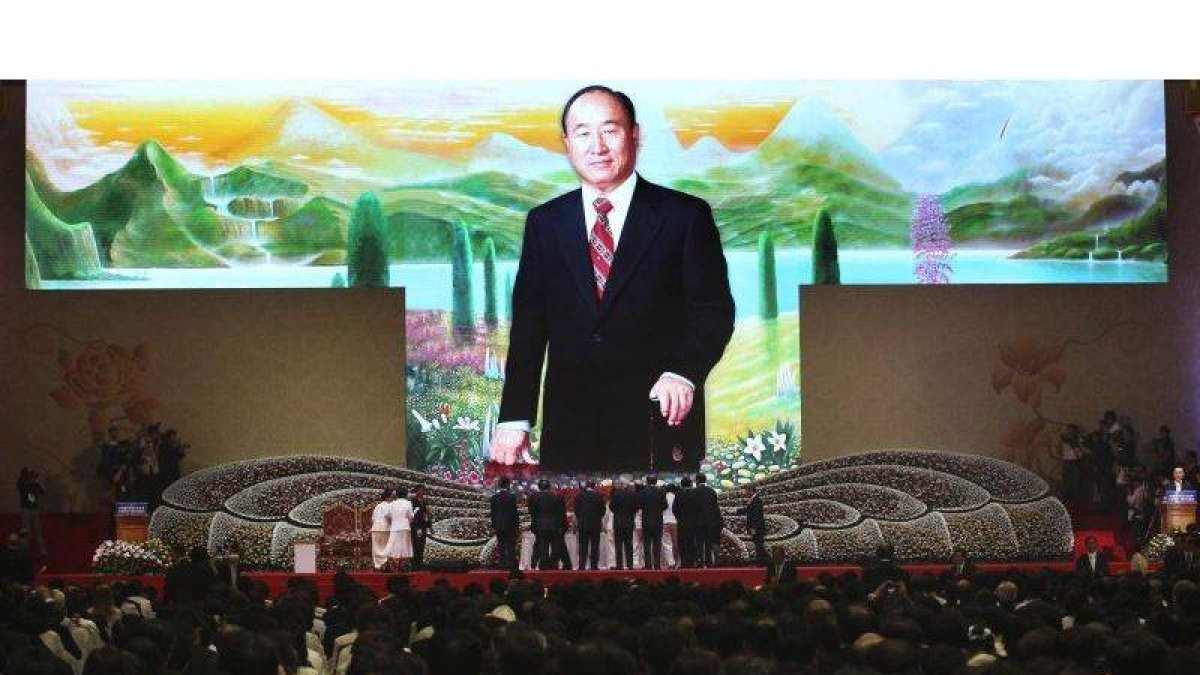 Familiares y amigos realizan una ofrenda floral durante la misa celebrada con motivo del primer aniversario de la muerte de su fundador, el reverendo Sun Myung Moon.