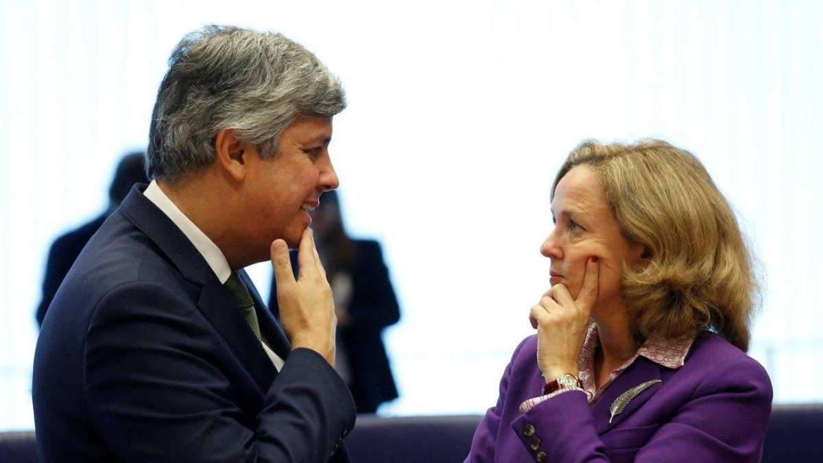 El presidente del Eurogrupo y ministro de Finanzas portugués, Mario Centeno, conversa con la ministra de Economía española, Nadia Calviño (d), antes de la reunión del Eurogrupo en Luxemburgo.