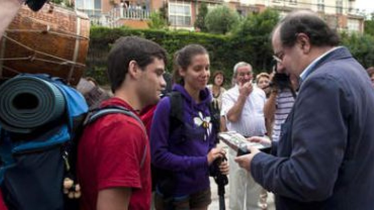 El presidente de la Junta, Juan Vicente Herrera, charla con dos peregrinos en Burgos.