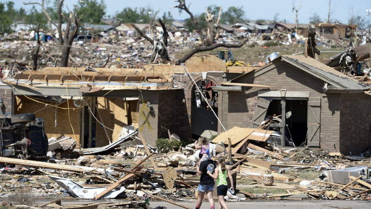 Una pareja y su hija caminan entre los escombros, en Moore, Oklahoma.