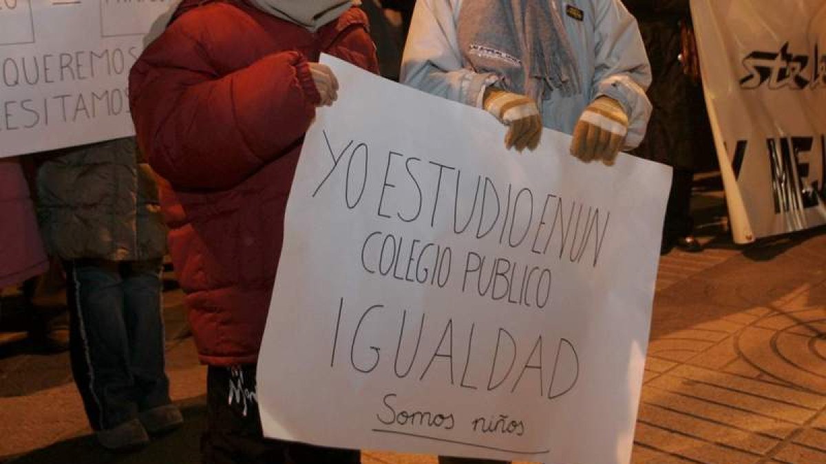 Dos niños sostienen una pancarta en defensa de la escuela pública. DL