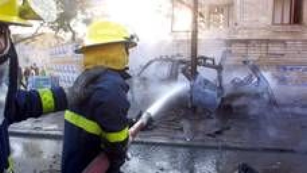 Unos bomberos trabajan en el lugar del atentado suicida cerca de una iglesia cristiana de Bagdad