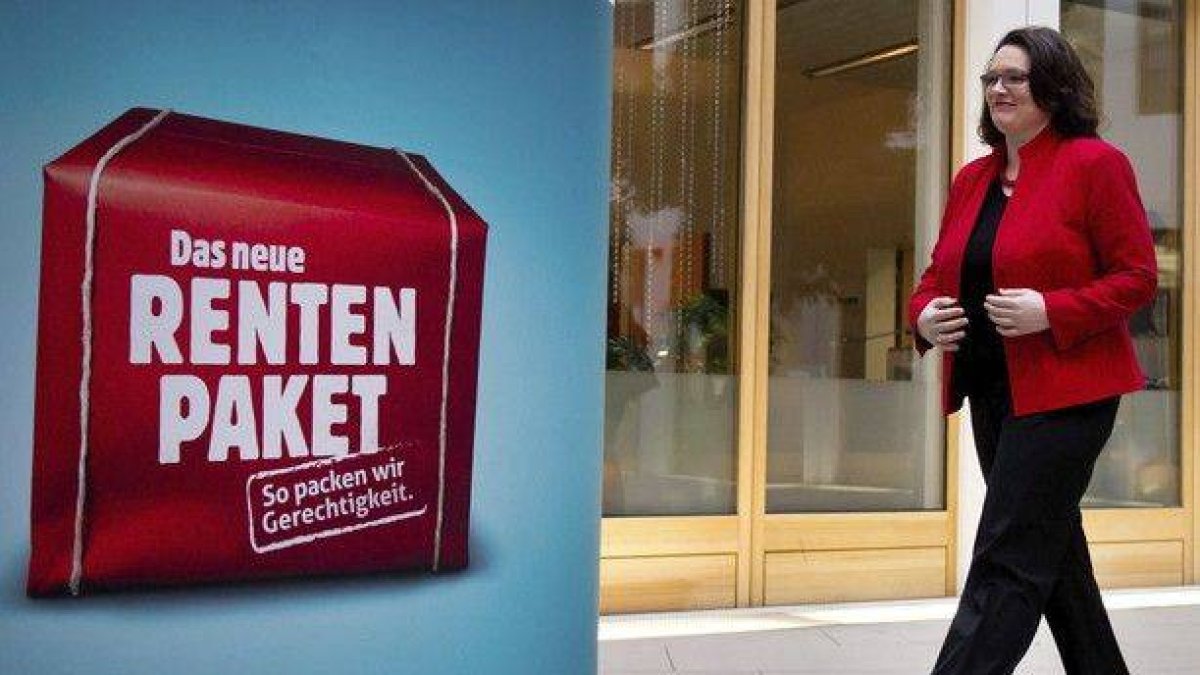 La ministra de Trabajo, la socialdemócrata Andrea Nahles, pasa junto a un cartel que anuncia la reforma de las pensiones, este miércoles, en Berlín.
