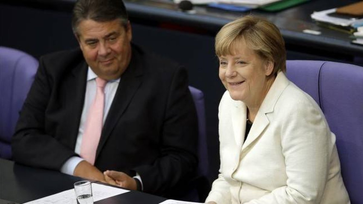Gabriel (izquierda) y la cancillera Merkel, en una sesión parlamentaria en el Bundestag, en Berlín, este martes.