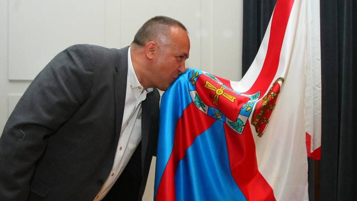 El nuevo presidente del Consejo Comarcal del Bierzo, el socialista Gerardo Álvarez Courel, besa la bandera del Bierzo al finalizar el pleno de constitución