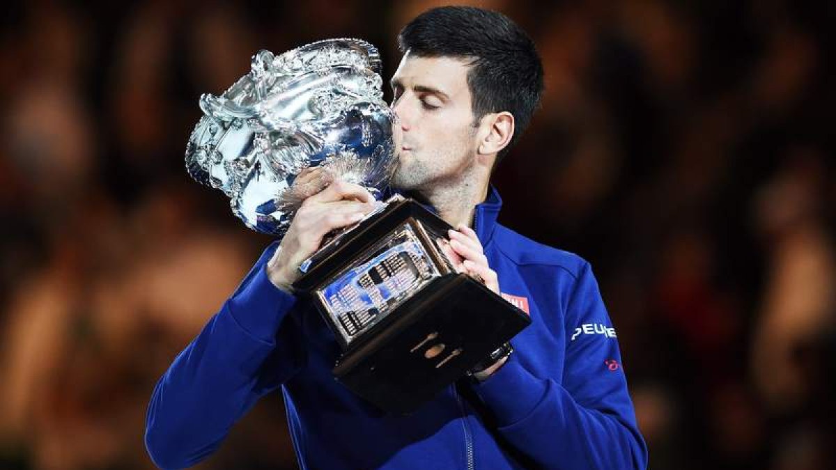 El serbio Novak Djokovic besa el trofeo que le acredita como campeón del Abierto de Australia.