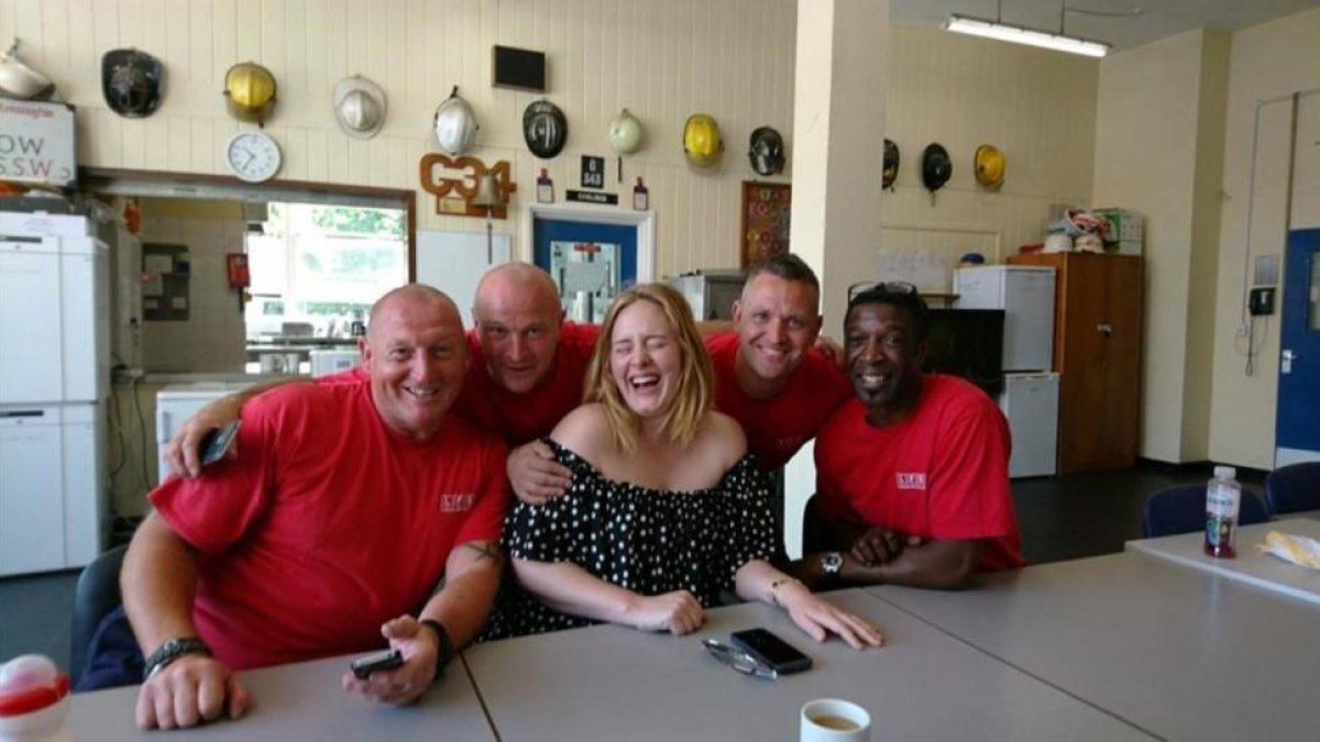 Adele posa con los bomberos.