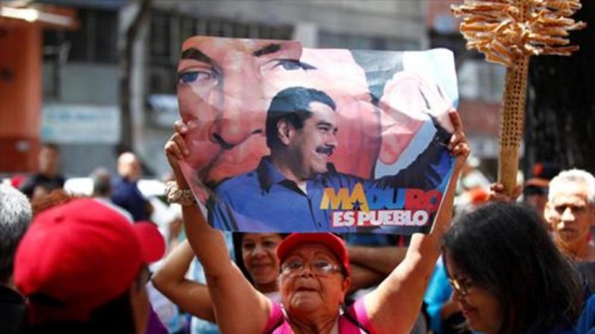 Una mujer, con una pancarta de apoyo a Maduro, el domingo, en Caracas