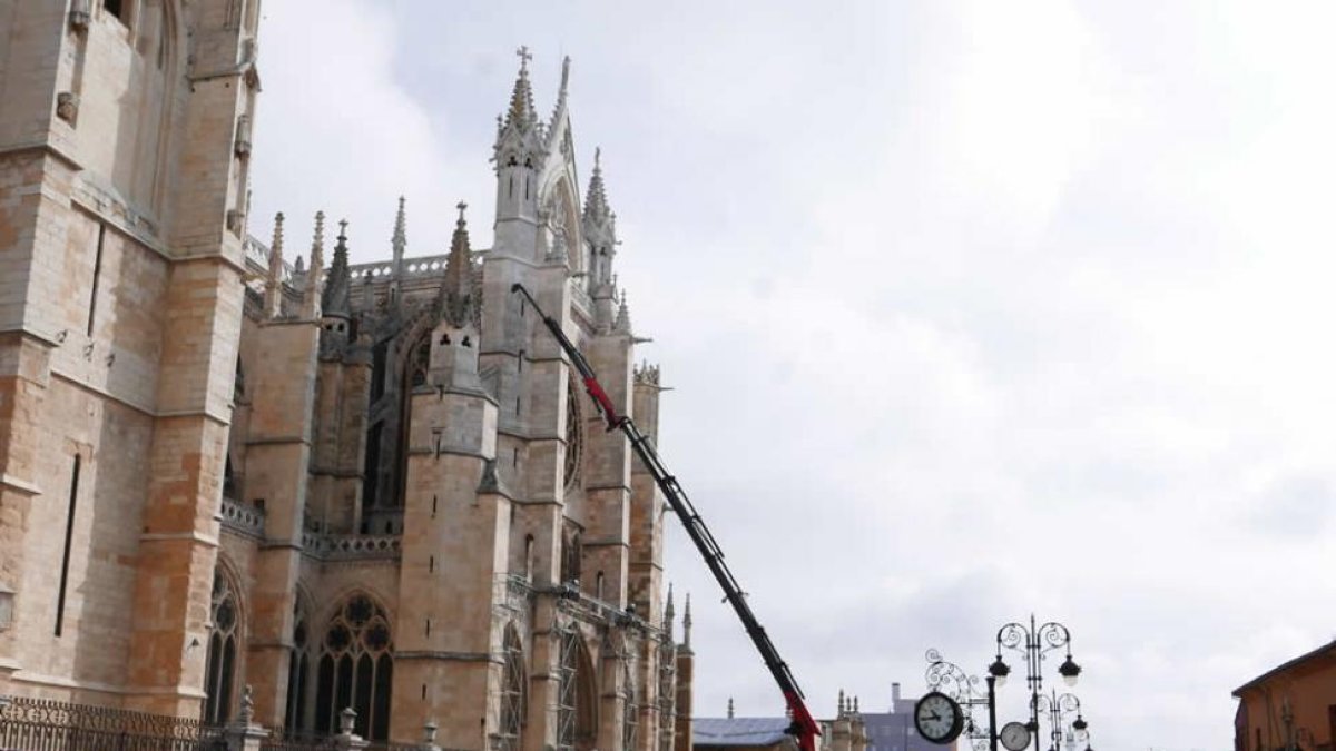 Una gigantesca grúa comenzó ayer a desmantelar la marquesina instalada en la fachada sur de la Catedral. JAVIER FERNÁNDEZ ZARDÓN