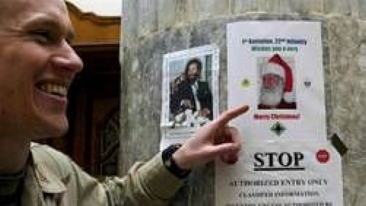 Un soldado estadounidense bromea con el cartel de Sadam Husein disfrazado de Papá Noel