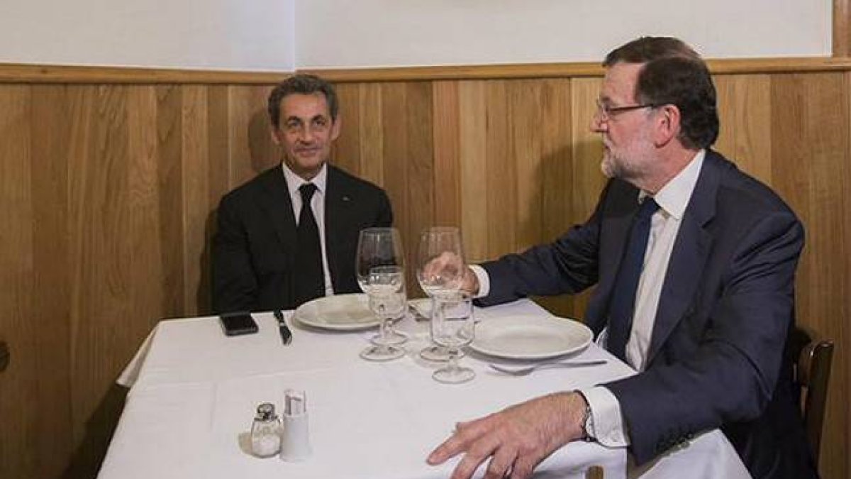 Sarkozy, con la pared a sus espaldas, en el restaurante al que le ha invitado Rajoy.
