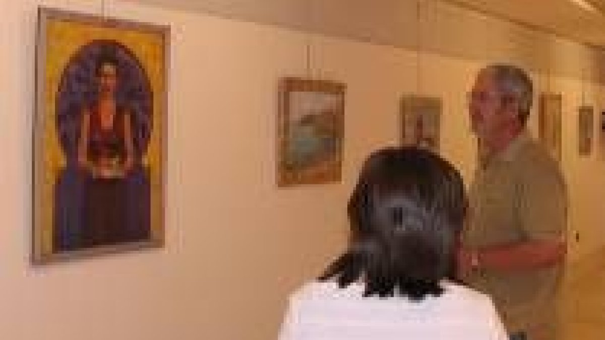 Dos visitantes de la exposición contemplan una de las pinturas