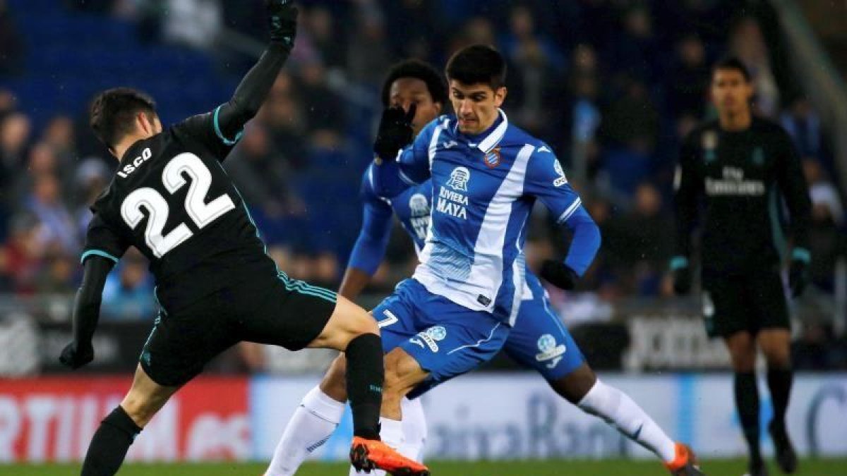 El delantero del Espanyol, Gerard Moreno (d), pelea un balón con el centrocampista del Real Madrid, Isco Alarcón (i), durante el partido de la vigesimosexta jornada de liga que se disputa en el RCDE Stadium.
