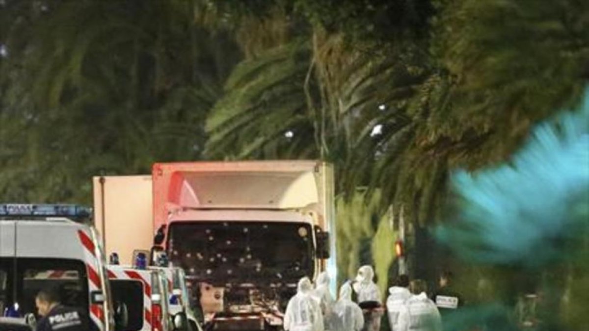 Un grupo de forenses examinan el camión del atentado de Niza.