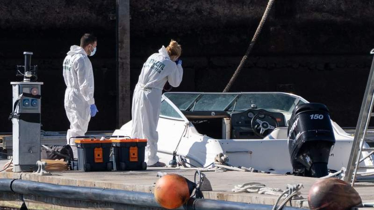 Dos miembros de la policía científica analizan el barco encontrado a la deriva. RAMÓN DE LA ROCHA
