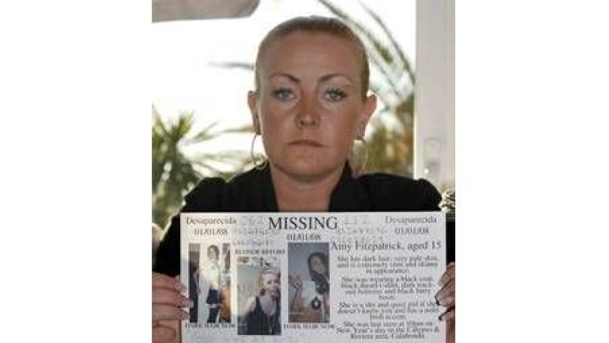 La madre de la niña posa con la foto de la desaparecida