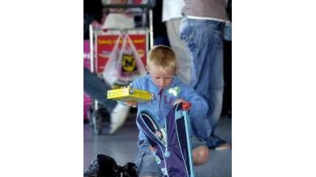Un niño guarda cosas en su mochila para facturar