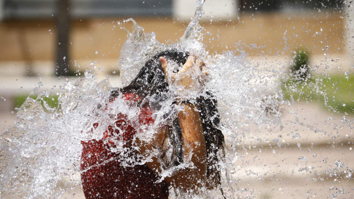 Una niña se refresca en una fuente en Córdoba. SALAS