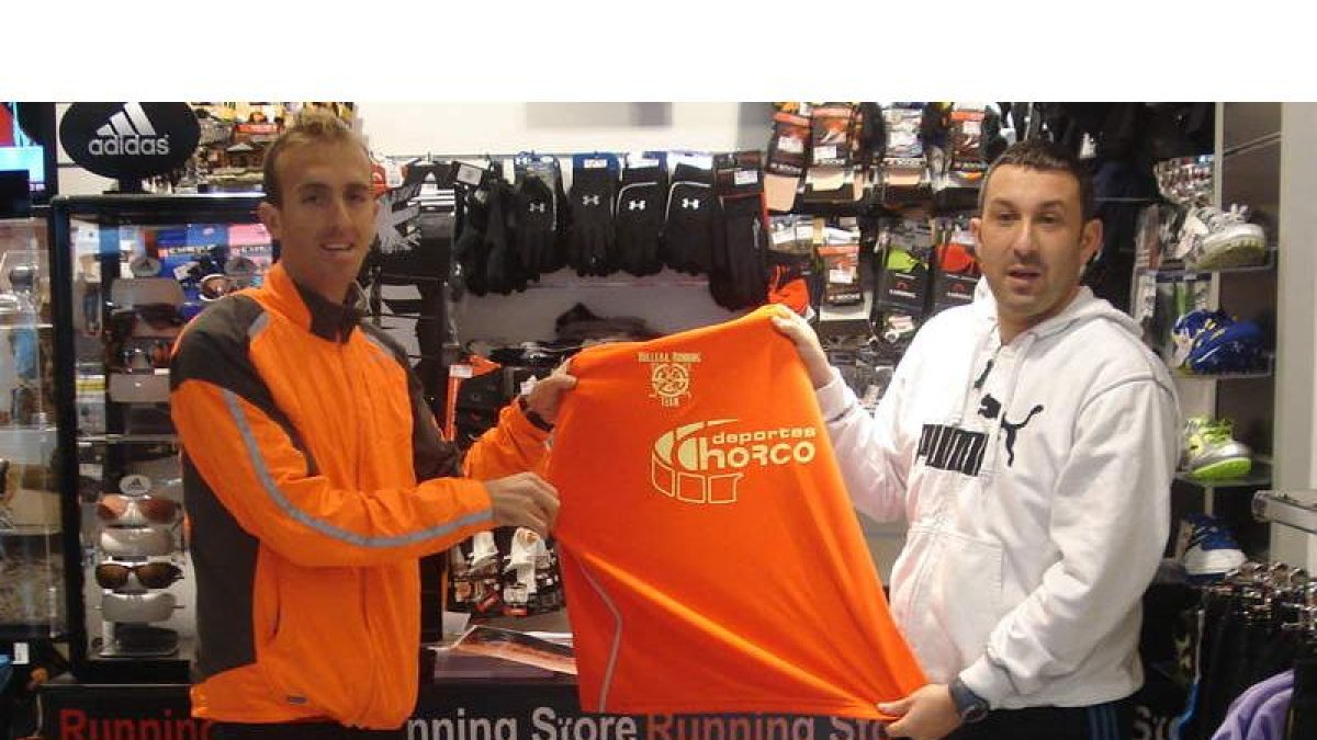 Sergio Sánchez y David con la camiseta que entregarán a los atletas.